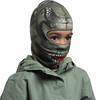 Kind mit Monster-Maske und grüner Jacke.
