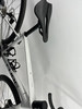 Ein Cube Attain Rennrad mit schwarzem Sattel hängt an einer weißen Wand.