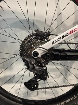 Shimano Deore Schaltwerk an einem Mountainbike mit der Aufschrift Enduro 2.0. Shimano Deore Schaltwerk an einem Mountainbike mit der Aufschrift Enduro 2.0.