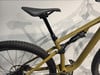 Ein gelbes Mountainbike mit Federung und schwarzem Sattel vor weißem Hintergrund.