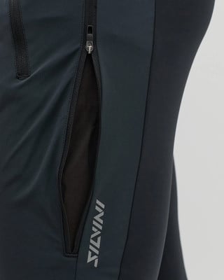 Detail tmavých sportovních kalhot se zipem a síťovanou kapsou.