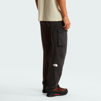 Mann in dunkler Cargohose mit The North Face Logo am linken Bein. Mann in dunkler Cargohose mit The North Face Logo am linken Bein.