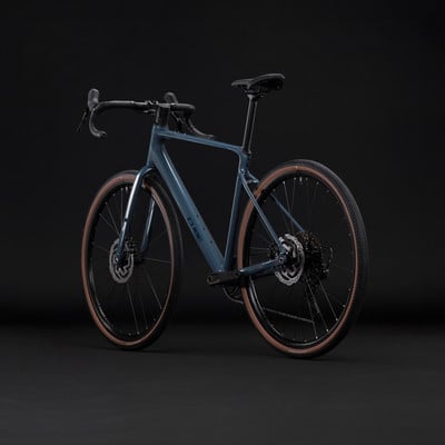 Graues Cube Gravelbike mit braunen Reifen vor schwarzem Hintergrund. Graues Cube Gravelbike mit braunen Reifen vor schwarzem Hintergrund.