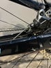 Detail einer Shimano-Hinterradbremse an einem beschädigten Fahrradrahmen.