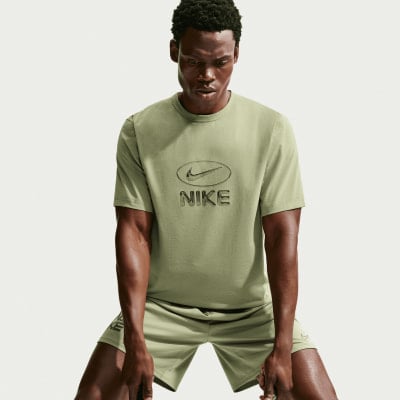 Mann in grünem Nike T-Shirt und Shorts