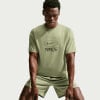 Mann in grünem Nike T-Shirt und Shorts
