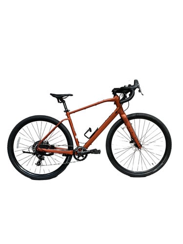 Orange Gravelbike mit schwarzen Rädern und Lenker.