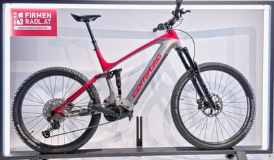 Corratec Mountain E-Bike in Rot und Silber auf einem Ständer.