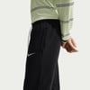 Schwarze Nike Jogginghose mit weißem Logo und gestreiftem Oberteil.