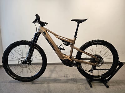 Goldenes E-Bike mit Federung auf einem Ständer, Nahaufnahme. Goldenes E-Bike mit Federung auf einem Ständer, Nahaufnahme.