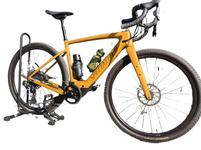 Ein gelbes Specialized Gravelbike auf einem Ständer mit Wasserflaschen.