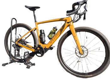 Ein gelbes Specialized Gravelbike auf einem Ständer mit Wasserflaschen.