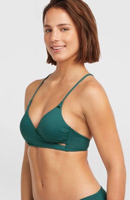 Ein Model in einem grünen Bikini mit überkreuzten Cups und seitlichen Details. Ein Model in einem grünen Bikini mit überkreuzten Cups und seitlichen Details.