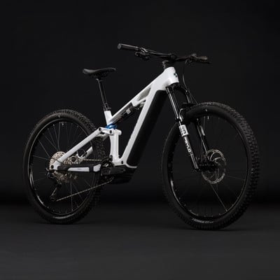 Modernes weißes E-Bike mit Federung und schwarzen Rädern vor dunklem Hintergrund.