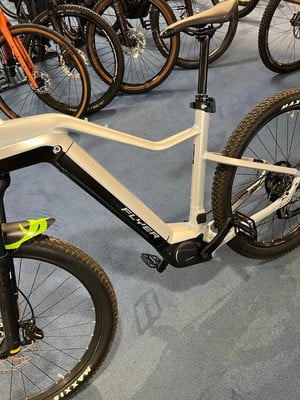 Detail eines E-Bikes mit Federung und breiten Reifen auf blauem Teppich. Detail eines E-Bikes mit Federung und breiten Reifen auf blauem Teppich.