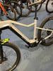 Detail eines E-Bikes mit Federung und breiten Reifen auf blauem Teppich.