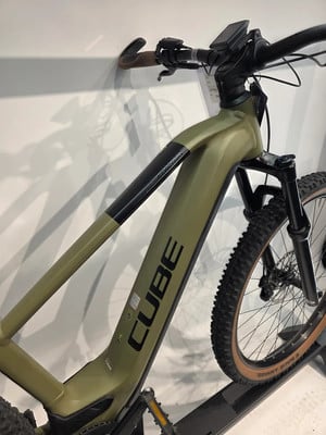 Ein grünes E-Bike der Marke CUBE mit schwarzem Schriftzug auf dem Rahmen.