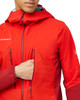 Ein Mann in einer roten Mammut-Jacke greift in die Seitentasche.