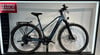 Blaues KTM E-Bike mit Gepäckträger und Schutzblechen vor weißem Hintergrund.