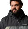 Ein bärtiger Mann in einer dunklen Kapuzenjacke mit Columbia-Logo.
