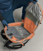Ein offener orangefarbener Rucksack mit Innentaschen und Gurten.