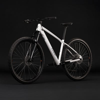 Ein weißes Mountainbike mit schwarzen Rädern und schwarzen Akzenten auf schwarzem Hintergrund.