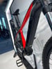 Ein rotes Mountainbike mit schwarzem Rahmen und Federung.