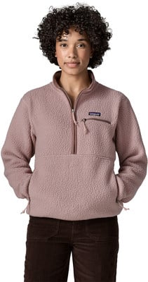 Ein Mädchen in einem rosa Fleece-Pullover mit kurzem Reißverschluss und brauner Cordhose. Ein Mädchen in einem rosa Fleece-Pullover mit kurzem Reißverschluss und brauner Cordhose.