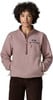 Ein Mädchen in einem rosa Fleece-Pullover mit kurzem Reißverschluss und brauner Cordhose.