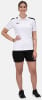 Eine Frau in einem weißen T-Shirt und schwarzer Hose posiert.