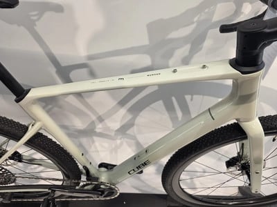 Ein weißes Cube Gravelbike mit schwarzen Details und Schatten. Ein weißes Cube Gravelbike mit schwarzen Details und Schatten.
