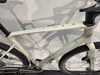 Ein weißes Cube Gravelbike mit schwarzen Details und Schatten.