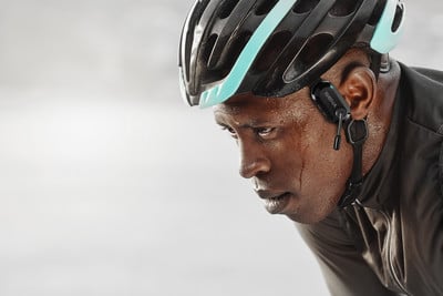 Ein Radfahrer mit Helm und Kopfhörern schwitzt, nachdenklicher Blick Ein Radfahrer mit Helm und Kopfhörern schwitzt, nachdenklicher Blick