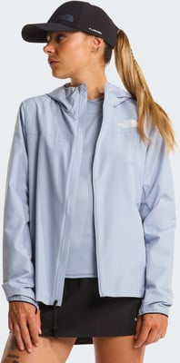 Eine Frau in einer blauen Jacke und schwarzer Kappe mit Pferdeschwanz. Eine Frau in einer blauen Jacke und schwarzer Kappe mit Pferdeschwanz.