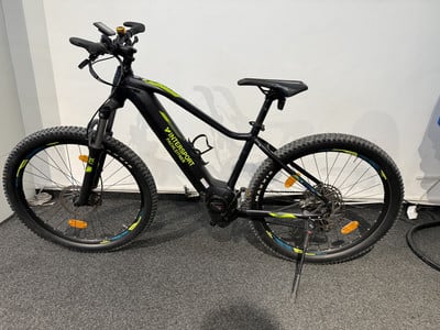 Schwarzes E-Bike mit Intersport-Logo und gelben Details an den Rädern. Schwarzes E-Bike mit Intersport-Logo und gelben Details an den Rädern.