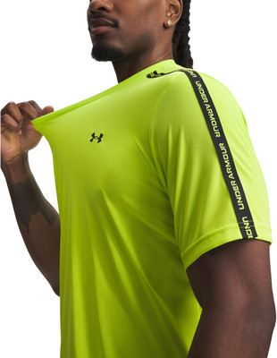 Ein Mann in einem neongelben T-Shirt mit Under Armour Logo auf dem Ärmel. Ein Mann in einem neongelben T-Shirt mit Under Armour Logo auf dem Ärmel.