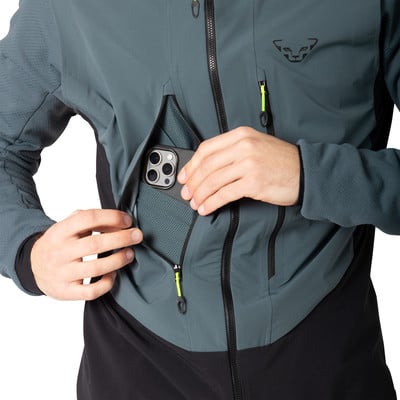 Ein Mann in einer dunklen Jacke steckt sein Handy in die Brusttasche.