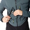 Ein Mann in einer dunklen Jacke steckt sein Handy in die Brusttasche.