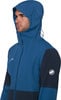 Mann in blauer Jacke mit Kapuze und Mammut-Logo auf dem Ärmel.