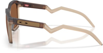 Braune Oakley-Sonnenbrille mit Logo und gezackten Bügeln. Braune Oakley-Sonnenbrille mit Logo und gezackten Bügeln.