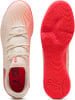Weiße Puma Fußballschuhe mit orangen Streifen und roter Sohle.