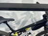 Ein schwarz-weißes E-Mountainbike mit Federung und Sattel vor weißem Hintergrund.