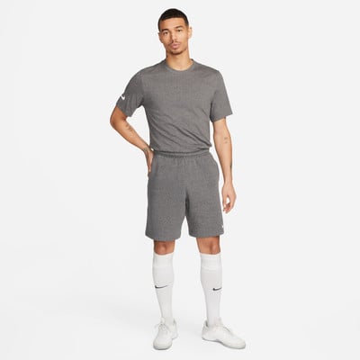 Ein Mann in einem dunkelgrauen T-Shirt und Shorts mit weißen Socken und Turnschuhen. Ein Mann in einem dunkelgrauen T-Shirt und Shorts mit weißen Socken und Turnschuhen.