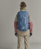 Eine Frau mit einem Rucksack in Outdoor-Kleidung, von hinten gesehen.