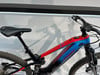 Ein rot-blaues Conway E-Mountainbike mit Federung.