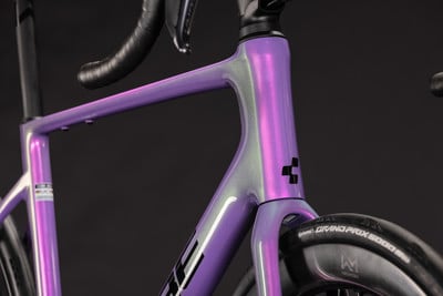 Detail eines violetten Rennradrahmens mit schwarzem Lenker. Detail eines violetten Rennradrahmens mit schwarzem Lenker.