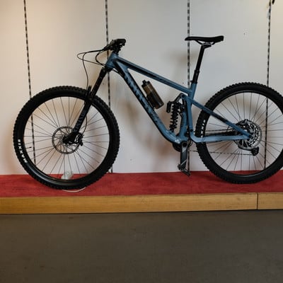 Ein Mountainbike mit Federung und schwarzen Rädern steht auf einem roten Teppich. Ein Mountainbike mit Federung und schwarzen Rädern steht auf einem roten Teppich.