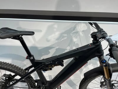 Ein schwarzes Mountainbike mit Federung und Display am Lenker. Ein schwarzes Mountainbike mit Federung und Display am Lenker.