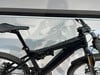 Ein schwarzes Mountainbike mit Federung und Display am Lenker.