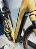 Ein gelbes Cube E-Bike mit braunem Sattel und schwarzen Pedalen.